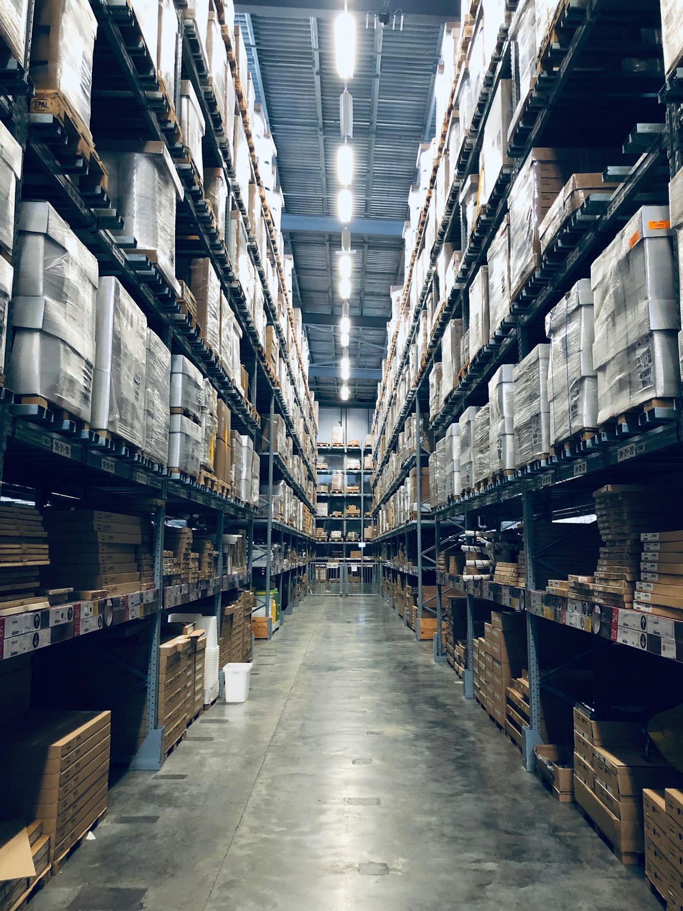 Modern high-bay warehouse aisle with fully stocked pallet racking